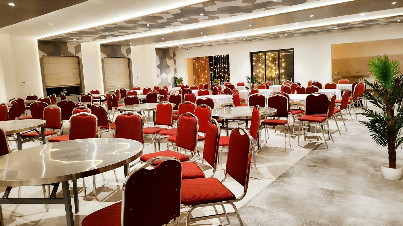 Banquet-style multipurpose hall set up with round tables and chairs, generic illustrative photo